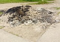 Старый асфальт лежит среди газона 